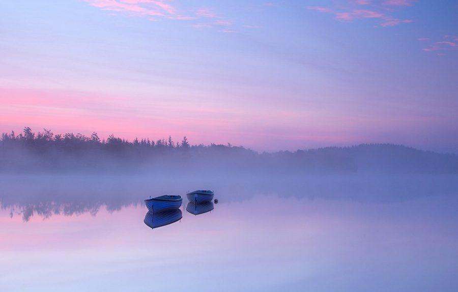 fotografia minimalista de barcos isolados em um lago calmo em tons de azul, rosa e violeta