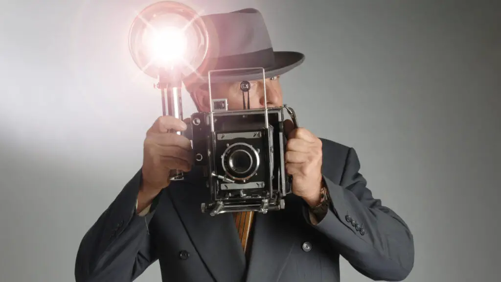 foto de um homem com câmera antiga para ilustrar como o flash funciona na fotografia