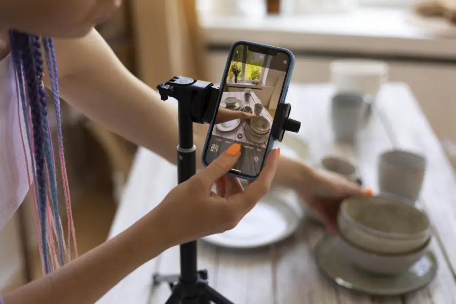 mulher fotografando louça com um celular - melhores cursos de fotografia online